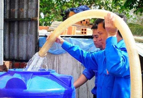 Đc Nguyễn Xuân Hùng - UVTV, Chánh Văn phòng TƯ Đoàn tiếp nước vào bồn chứa cho các hộ dân.jpg